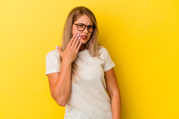 Young russian woman isolated on yellow background having a strong teeth pain, molar ache.