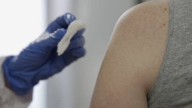 Doctor injecting flu vaccine to patient's arm in local hospital. coronavirus vaccine.