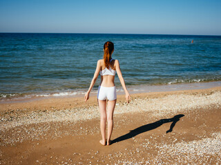 woman in white swimsuit yoga exercise beach lifestyle ocean