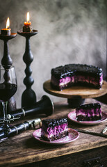 Chocolate blueberry cheesecake. A piece of cheesecake in focus. Bokeh effect.