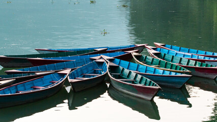 Fototapeta na wymiar Multicolored tourists boats on the Phewa lake, Pokhara, Nepal