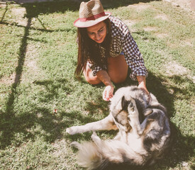 Smiling  beautiful Woman having fun and  hugging  cute siberian Husky dog at the back Yard .   Curvy woman Playing with her dog outdoor