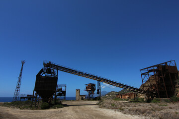Strutture abbandonate e degradate dal tempo e dall&rsquo;incuria, di una vecchia miniera in disuso, sotto un cielo blu intenso