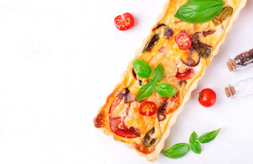 Quiche with egg, tomato, caramelized onion, basil and cheese. French cuisine pie. Copy space