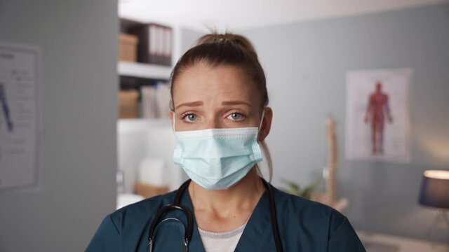 Caucasian Female Nurse Wearing Surgical Mask Standing In Doctors Office