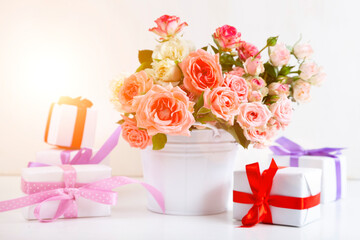 Bouquet of pink roses and boxes with gifts