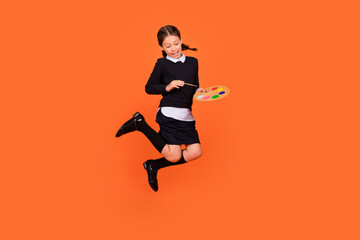 Full body photo of young girl happy positive smile artist draw paint brush jumper isolated over orange color background