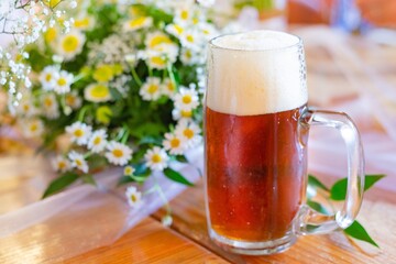 Glass pint of beer served on wedding decorated table