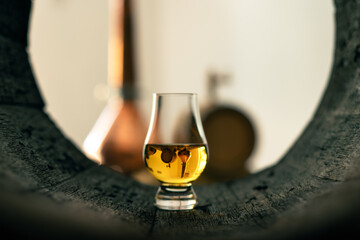 A glass of whiskey in oak barrel - obrazy, fototapety, plakaty