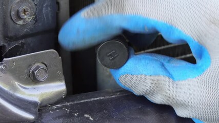 The service of checking the car air conditioner. The Refrigerant Recharge System. Car service. The hands of the master unscrew the protective cap on the nipple of the air conditioner. Macro