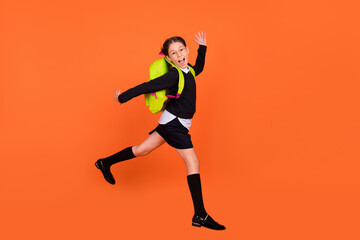 Full length profile side photo of young school girl happy positive smile jump run 1-september isolated over orange color background