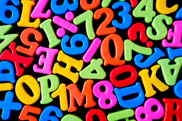 Background with letters and symbols as a school education concept. Cheerful bright letters.