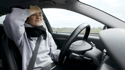 Young woman with natural look driving a passenger car on a German highway. The young woman shows various emotional reactions to the traffic event.