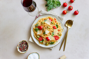 Spaghetti pasta with tomatoes, basil, olives and Parmesan cheese. Healthy eating. Vegetarian food.