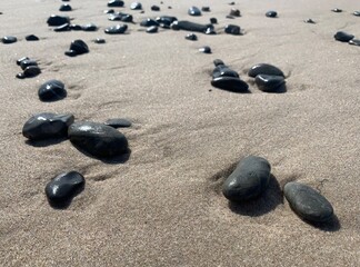 Fototapeta na wymiar Sea pebbles on the sand, sandy beach, natural colors