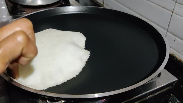 Bread or Appam delicious breakfast food Kerala style cooked by human hand in a non stick frying pan closeup shot