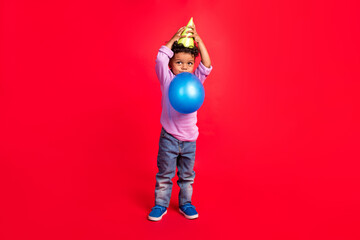 Full length body size view of attractive preteen guy blowing ball having fun isolated over bright red color background