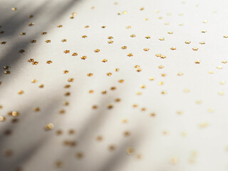 Golden stars in the form of confetti on beige background