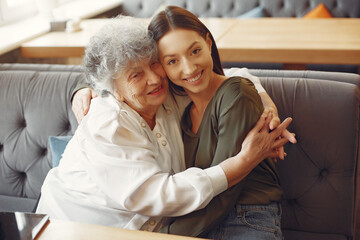 Old woman in a cafe with young granddaughter