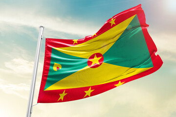 Grenada national flag waving in beautiful clouds.