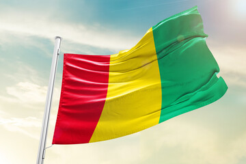 Guinea national flag waving in beautiful clouds.