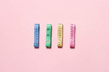 Collection of colorful measuring tapes on bright background.