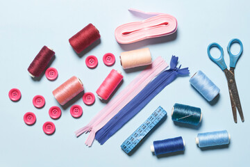 Sewing items from above. Flat lay composition with sewing accessories on light color background. Items for sewing, Sewing clothes, measuring tape, tailoring scissors, threads, buttons and needles