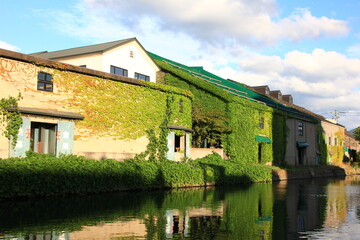 Fototapeta na wymiar 北海道の風景。小樽運河。運河とその岸辺に立つレトロな倉庫。