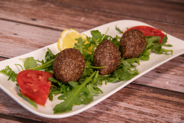 Traditional kebbe and pita bread on big round plate in lebanese restaurant. High quality photo