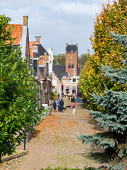 Fototapeta na wymiar Street scene of Voorstreek with people walking in city of Sloten, Sleat, Friesland, Netherlands