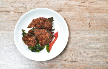 spicy stir fried crispy catfish curry with basil leaf on plate
