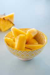 Yellow bowl with pieces of delicious and juicy pineapple to take as a fruit aperitif