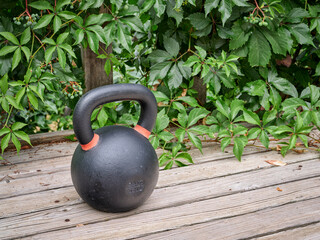 Fototapeta na wymiar heavy iron competition kettlebell for weight training on wooden grunge deck, home gym and fitness concept