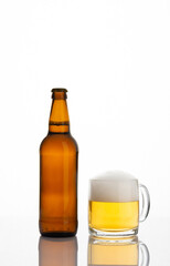 Brown full bottle of beer and glass with beer and foam isolated on white background