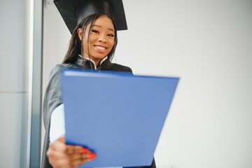 African American graduate holding diploma.