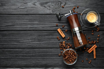 Manual coffee grinder with powder and beans on wooden table, flat lay. Space for text