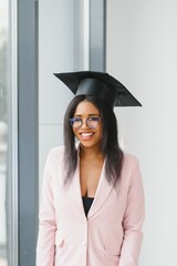 happy african american female student with diploma at graduation