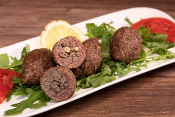 Traditional kebbe and pita bread on big round plate in lebanese restaurant. High quality photo
