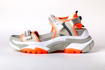 Women's, fashionable, sports sandals with orange accents on a white background. New youth shoes for...