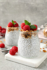 Delicious chia pudding with raspberries and granola on grey table