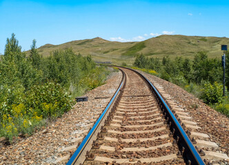 Railway in the steppe. Outskirts of Ust-Kamenogorsk (Kazakhstan). Central Asia. Bright summer landscape