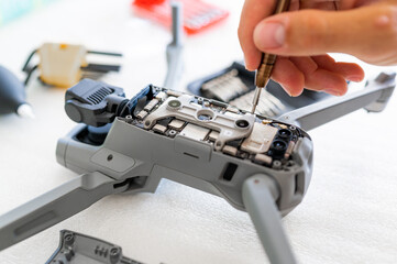 close-up male hand assembling gear and screwing an opened drone.