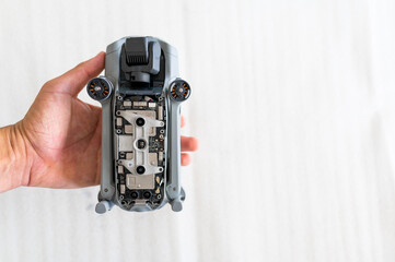 Top view male hand holding an opened drone to show circuit board. Isolated on white background with copy space.