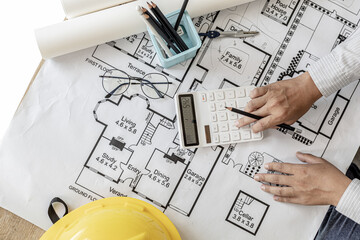 The architects pressed a calculator to calculate the area in a blueprint, designing the house...