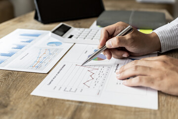 Financial scholars are looking at numbers on financial documents to verify the accuracy of company financial data, financial status documents line and pie charts. Finance concept.