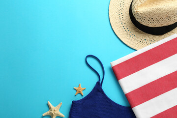 Flat lay composition with different beach objects on light blue background, space for text