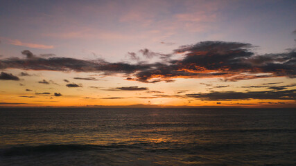 Fototapeta na wymiar Amazing Orange color sunset sky and ocean waves crashing on beach.Landscape Aerial view backgrounds