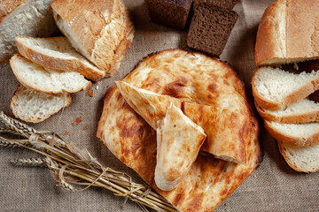 An assortment of baked breads. Various types of bread on the table. A loaf of bread. Private bakery.