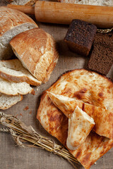 An assortment of baked breads. Various types of bread on the table. A loaf of bread. Private bakery.