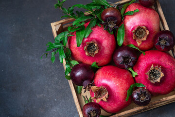 Fresh, ripe pomegranates in a wooden box